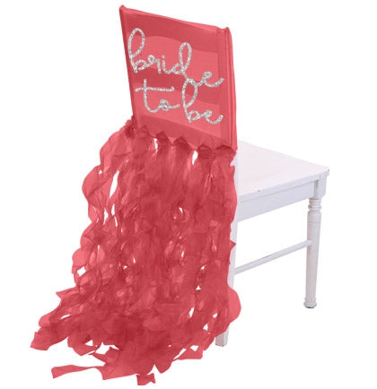 The sheer red organza chair cover says Bride to Be in a a silver glitter font.