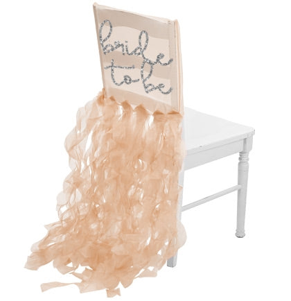 The sheer gold organza chair cover says Bride to Be in a a silver glitter font.