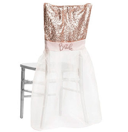This organza and sequin chair cover will make the bride the center of attention and have her feeling special. Made of sheer rose gold organza, sparkly sequins and a glitter graphic that says BRIDE. 