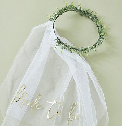 Have a bohemian bride who wants to stand out at her parties? This stunning plastic eucalyptus crown with white veil says 'Bride to Be' in a gold foil graphic.