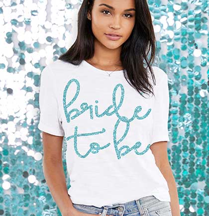 White jersey crew neck tshirt with an aqua glitter Bride To Be graphic on the front.