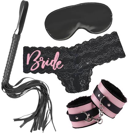 Black lace thong that says Bride in light pink on the right hip, a silky black blindfold mask, a black faux leather whip and a pair of black and light pink fuzzy and faux leather handcuffs. 
