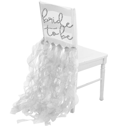 The sheer white organza chair cover says Bride to Be in a a silver glitter font. 