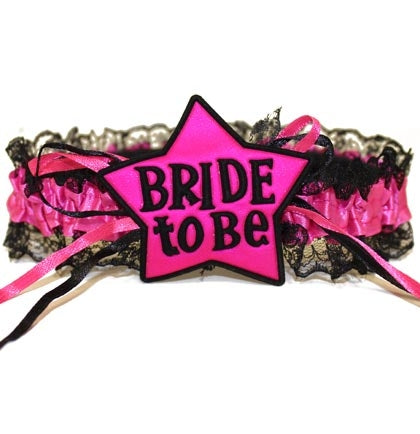 Let everyone know the Bride is the star of the show on her last night out with this hot pink and black garter! Made of stretch lace and satin, this garter has real lace trim and says "Bride to be"!