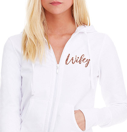 This 95% cotton and 5% spandex french terry hoodie has a glitter graphic on the front that says Wifey in silver. 