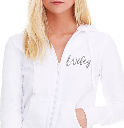 This 95% cotton and 5% spandex french terry hoodie has a glitter graphic on the front that says Wifey in silver. 