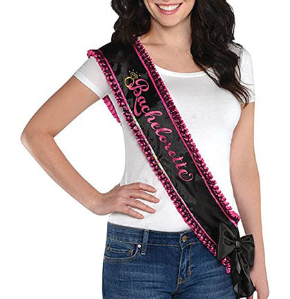 This satin and lace sash is an adorable way for the bride to stand out in the crowd! The black and hot pink sash says Bachelorette with a lace ruffle trim accented with a black bow at the bottom. The bride will loving standing out in the crowd at her party!