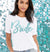 White jersey crew neck tshirt with an aqua glitter Bride graphic on the front. 